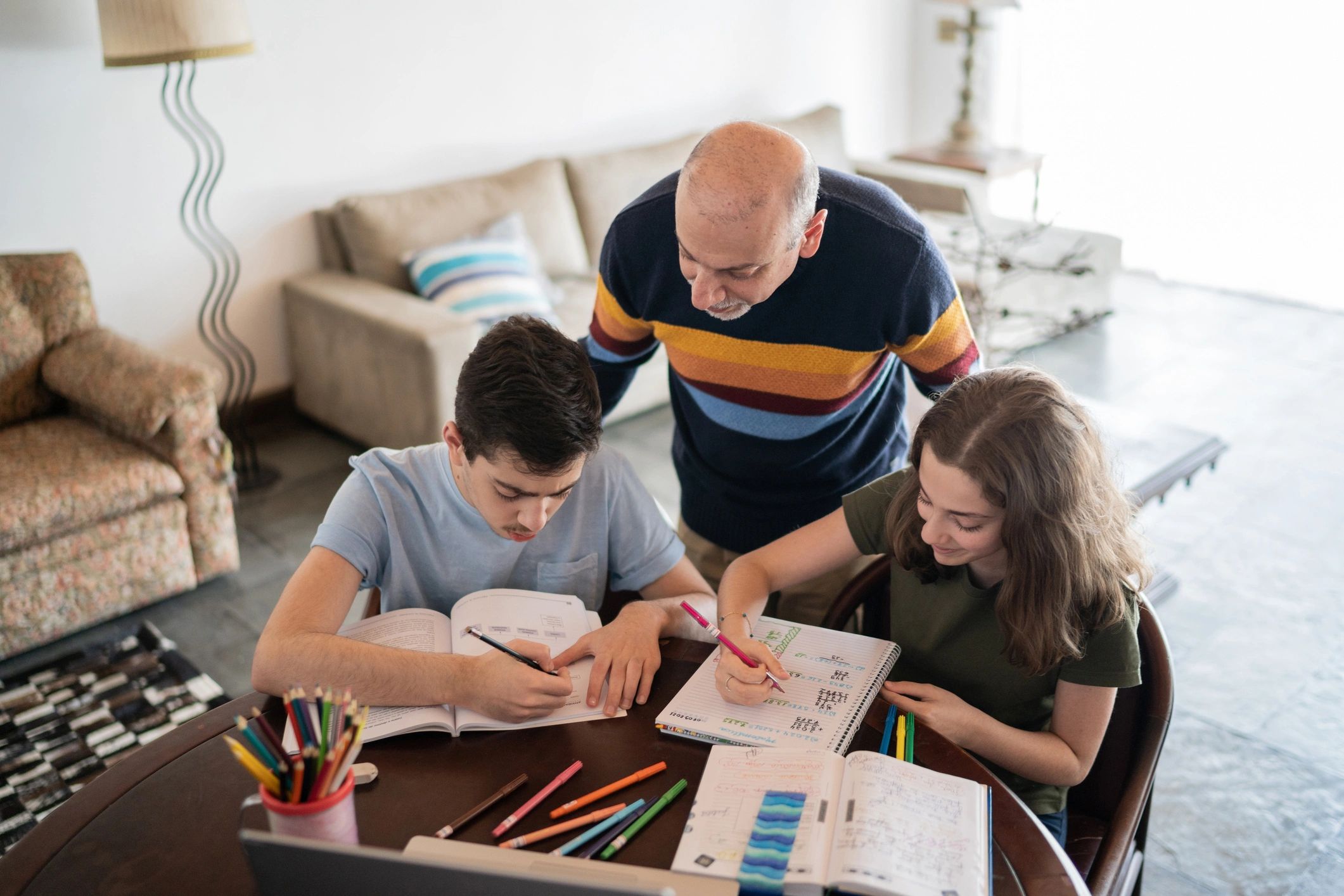 Father helping children with homework at home
