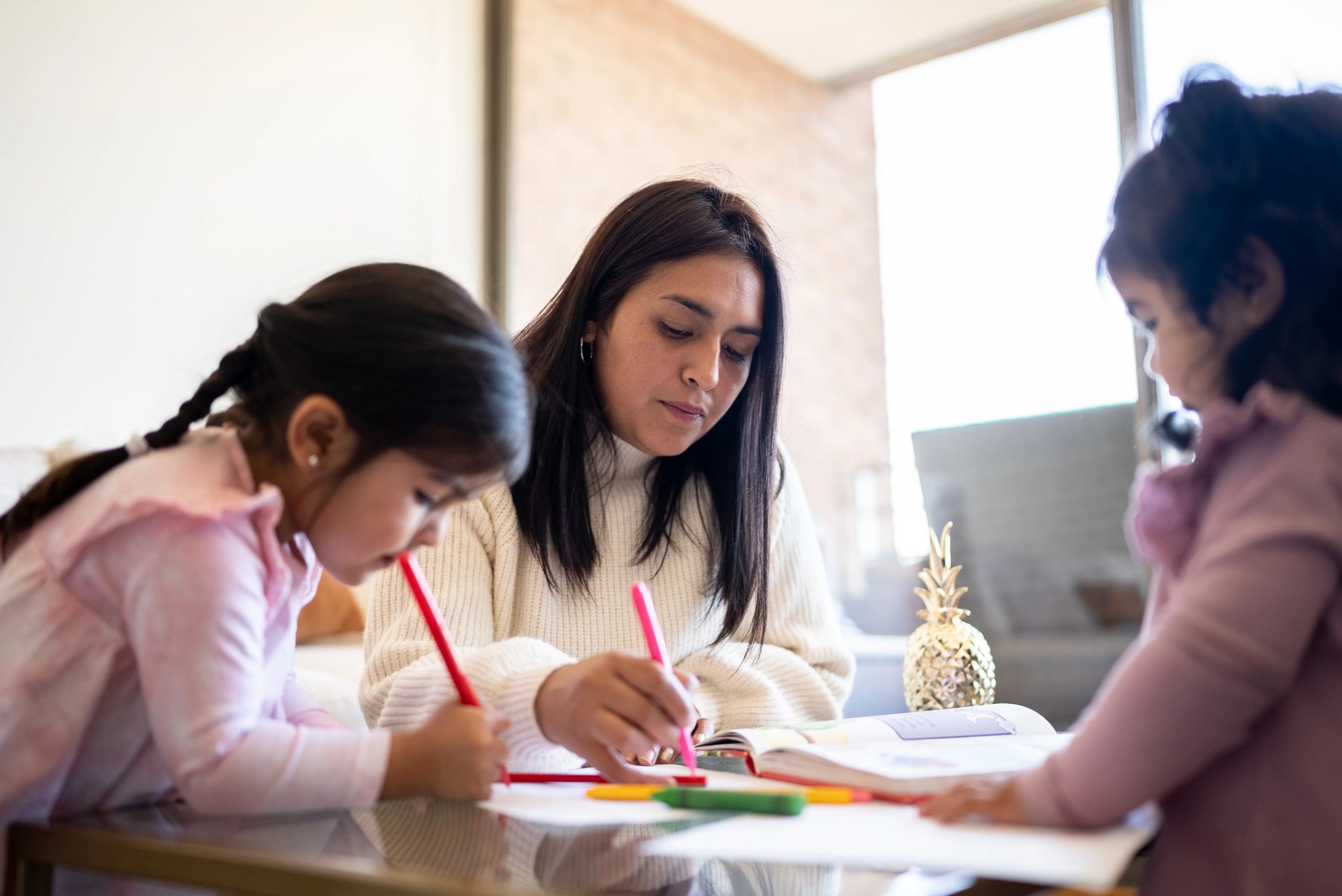 Mother drawing with daughters at home