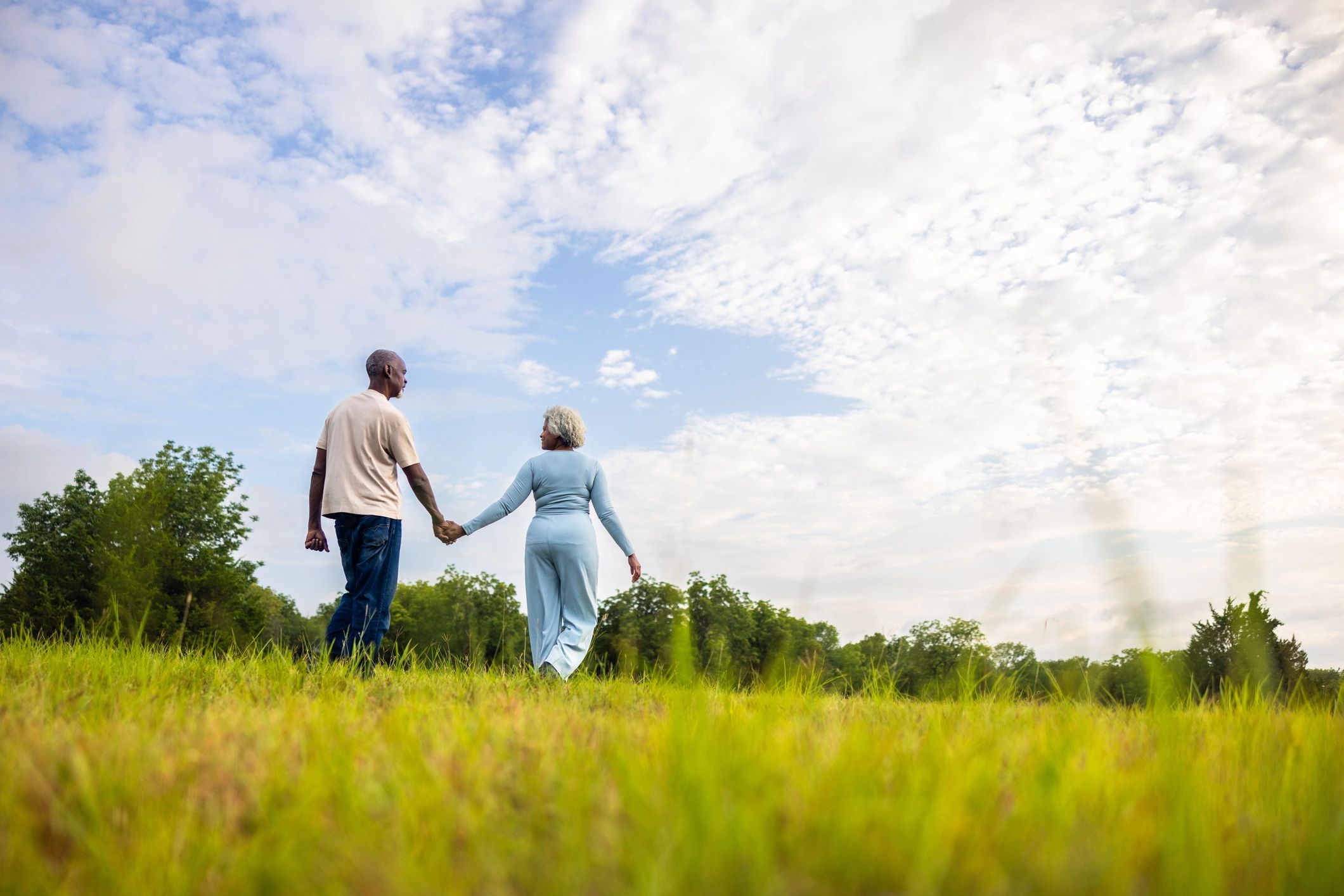Senior couple walking in a green landscape representing retirement peace of mind