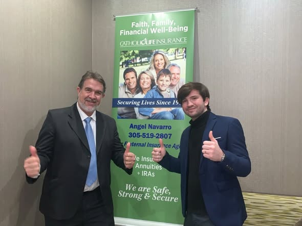 Navarro Insurance Group team members posing in front of a Catholic Life Insurance banner